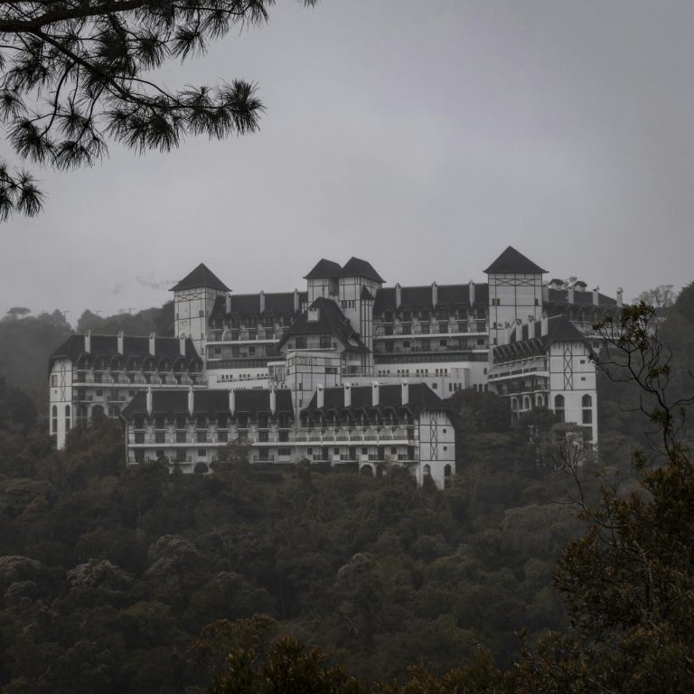 A captivating foggy scene featuring a majestic castle surrounded by lush greenery in Campos do Jordão, Brazil.